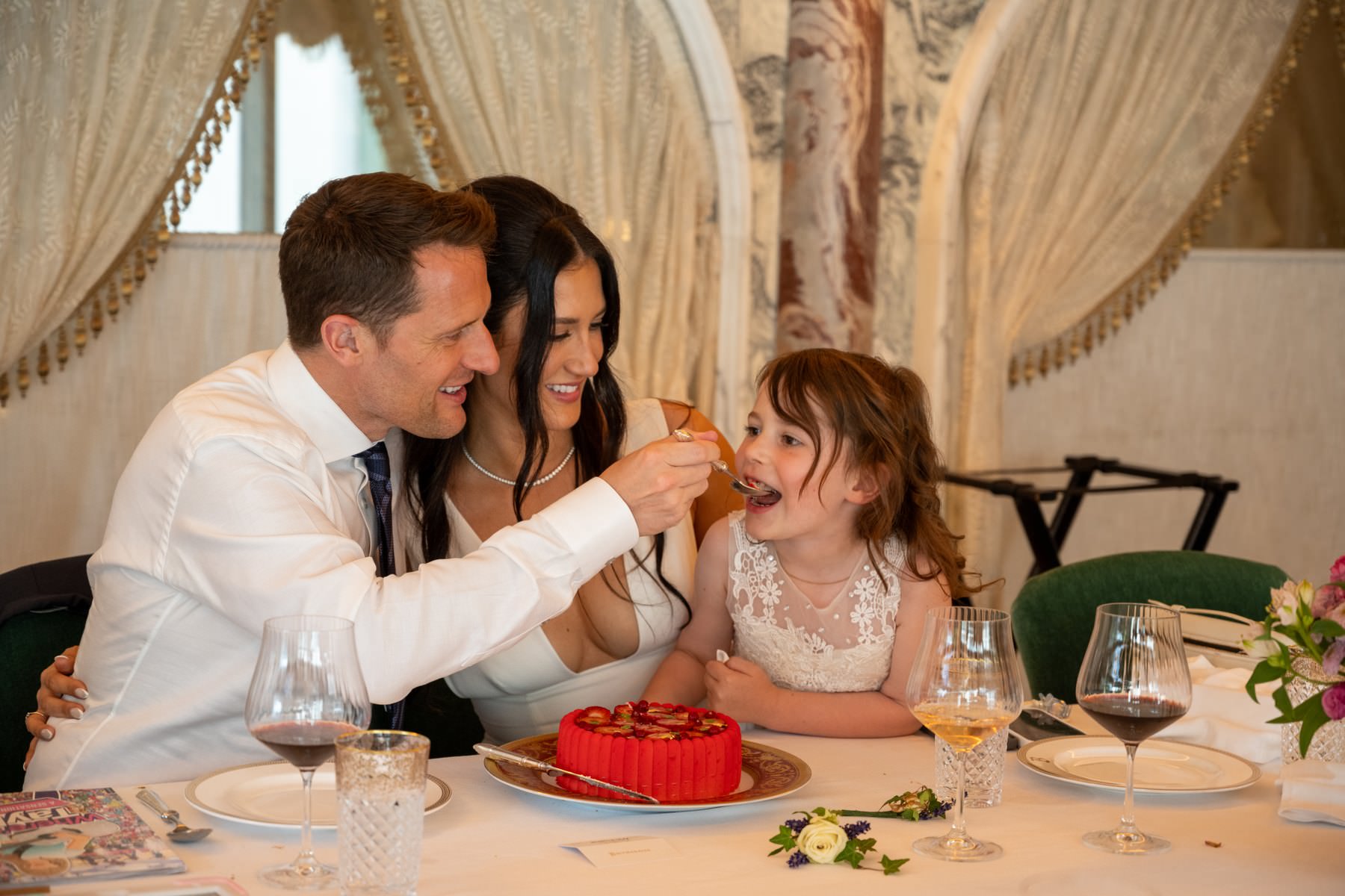 Matt feeding his daughter a spoonful of wedding cake at the table in Bacchanalia